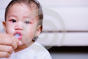 Asian baby sick but refuses eating medicine by syringe