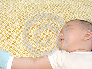 Asian baby sleeping at the side with arm stretched
