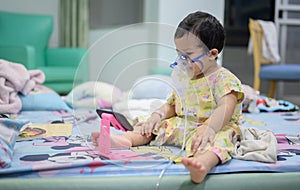 Asian baby was sick as Respiratory Syncytial Virus RSV in kid hospital. Thai little girl having inhaler containing medicine