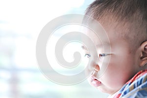 An Asian baby is wondering in the morning sunshine.