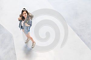 Asian backpack traveler woman wearing hat looking up and smile, top view with copy space. Journey trip travel lifestyle concept