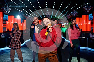 Asian band singing and dancing at karaoke party at night club