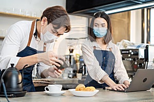 Asian Barista couple enjoy doing digital marketing in cafe restaurant. Businesspeople owner partner feel happy, take photo of