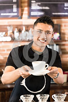 Asian Barista offering cup of drip brew coffee