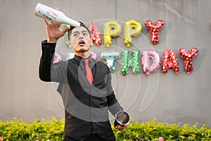 Asian bartender is warming up by practicing throwing bottles at a birthday party