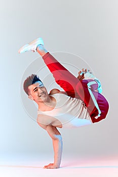 Asian Bboy standing in freeze stunt upside down balancing in air with legs photo