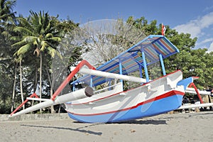 Asian beach scene with outrigger boat