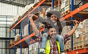 Asian beard father worker working at warehouse factory carrying his little African son on shoulders, having fun, smiling, playing