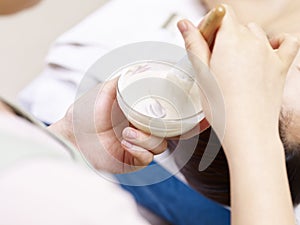 Asian beautician preparing for facial treatment