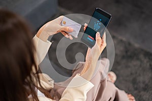 Asian beautiful businesswoman make payment by credit card via mobile phone for shopping online, selective focus at payment via