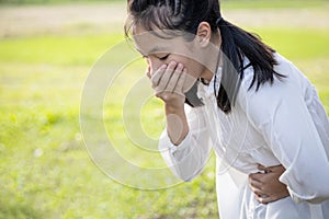 Asian beautiful child girl covered her mouth about to throw up,vomit,puke retch barf,woman feeling sick from indigestion or food