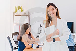 Asian beautiful empower woman holding laptop and friend working at meeting room in office.Owner businesswoman startup with