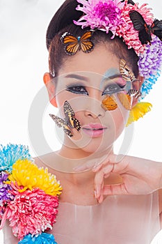 Asian Beautiful Girl With colorful make up with fresh Flowers and Butterfly