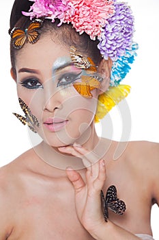 Asian Beautiful Girl With colorful make up with fresh Flowers and Butterfly