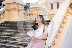 Asian beautiful girl reading book during the break outdoors