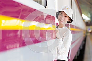 Asian beautiful girl was walking onto the train to travel while the train was parked at the platform