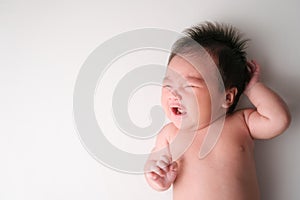 Asian beautiful newborn crying and hungry baby lying on the bed. Healthy little kid shortly after birth