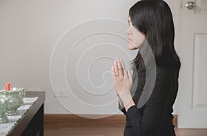 Asian beautiful woman with hand in praying worship postures with buddha statue