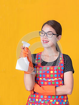 Asian beautiful woman holding a bottle spray  to clean the device and smiling happily to clean the house