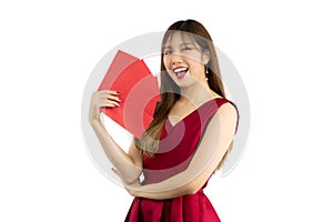 Asian beautiful woman long hairstyle wearing elegant red dress holding red money envelopes smiling and looking camera