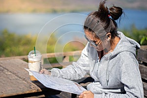 Asian beautiful woman reading menu at restaurant with coffee cup on the table