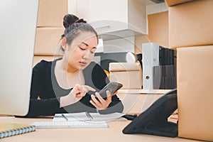 Asian beautiful woman Receiving order by phone and notebooks in selling products online