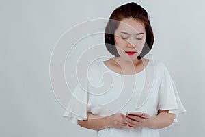 Asian beautiful woman Standing in a white shirt Mobile phone stand press Prepare to make a call. With a happy smile With a white