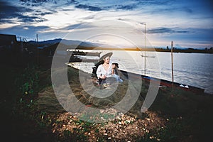 Asian Beautiful woman in Thai local dress working with fishing net in fishing village with field and lake background