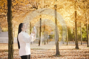 Asian beautiful woman is travel for holiday in the winter of Europe and view autumn leaves of big tree in Lausanne city at Switzer