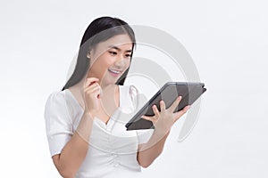 Asian beautiful woman in white shirt look at on tablet in her hand excitedly on white background