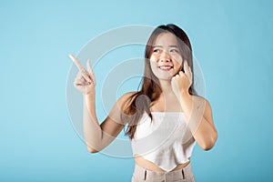 Asian beautiful young woman finger pointing to empty copy space