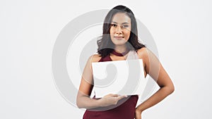 Asian beautiful young woman holding empty blank paper. A studio portrait with white background .Empty Space for text .She have tan