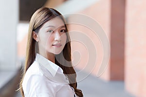 Asian beautiful young woman student is smiling and looking at camera in university background