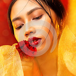 Asian Beauty Model Face. Women Full Red Lips Make up and Smooth Skin Care. Chinese Woman with Red Flower and Golden Fabrics