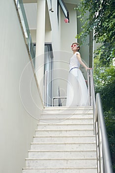 Asian beauty standing on the steps of villa, posing for photography during vacation