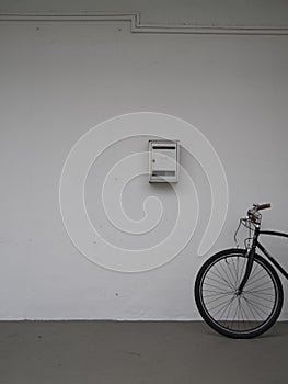 Asian bicycle against white wall with letter box
