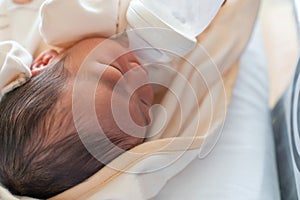 Asian big newborn baby feeding milk in bottle