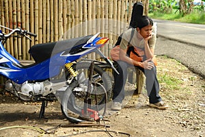 Asian biker roadside breakdown.