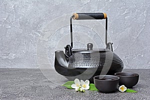 Asian black traditional teapot and teacups with green jasmine tea