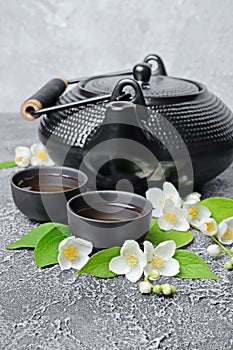 Asian black traditional teapot and teacups with healthy green jasmine tea