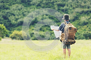 Asian boy backpack checking map in jungle forest, trips adventure and tourism for destination and leisure for education and relax photo