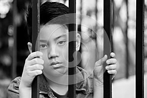 Asian boy behind iron bars