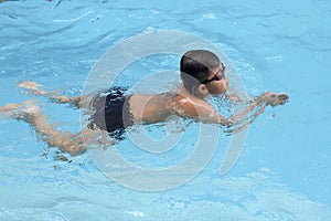 Asian boy breast stroke swims in swimming pool