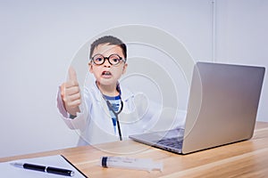 Asian boy doctor using a laptop computer