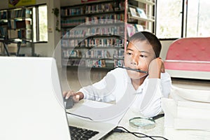 Asian boy doing homework .