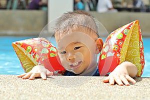 Asiático chico sobre el borde de un nino piscina 