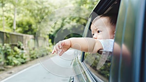 Asian boy extend hand outside open window car