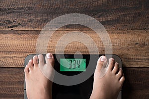 Asian boy feet on a weighing scale