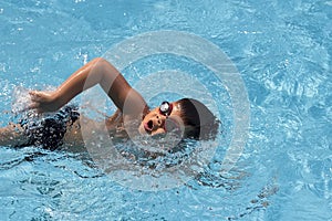 Asian boy front crawl swims in swimming pool