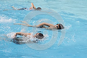 Asian boy front crawl swims in swimming pool